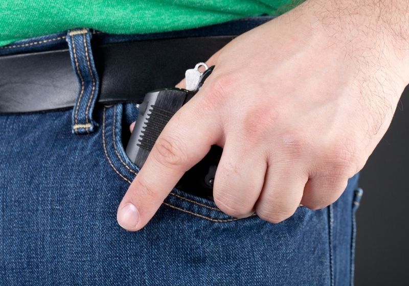 A man draws a small concealed handgun out of his pocket Cellphone gun SS