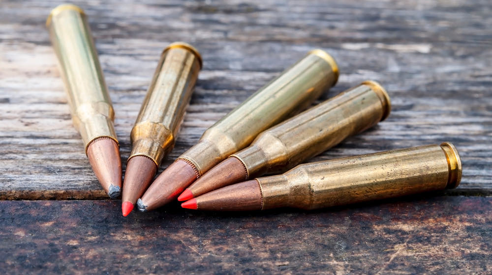 Five different caliber rifle bullets together on a wooden background | Here's What You need to Know About Tipped Bullets | featured