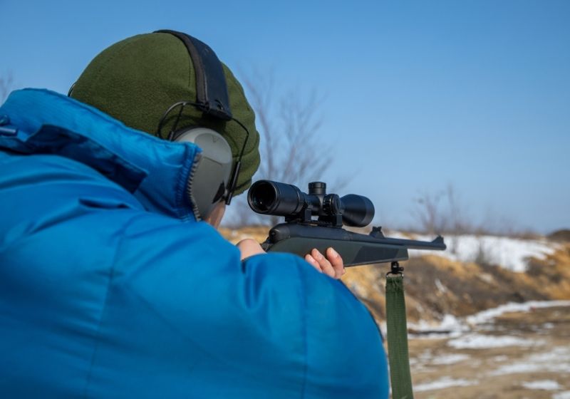 A shooter looks through a telescopic sight How to aim a rifle SS