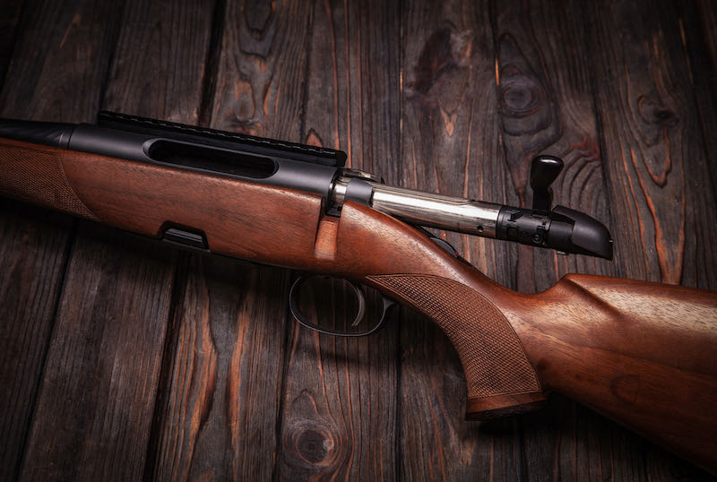 Rifle with a wooden stock on a dark background | henry.22 rifles lever action - Thompson/Center Hawken