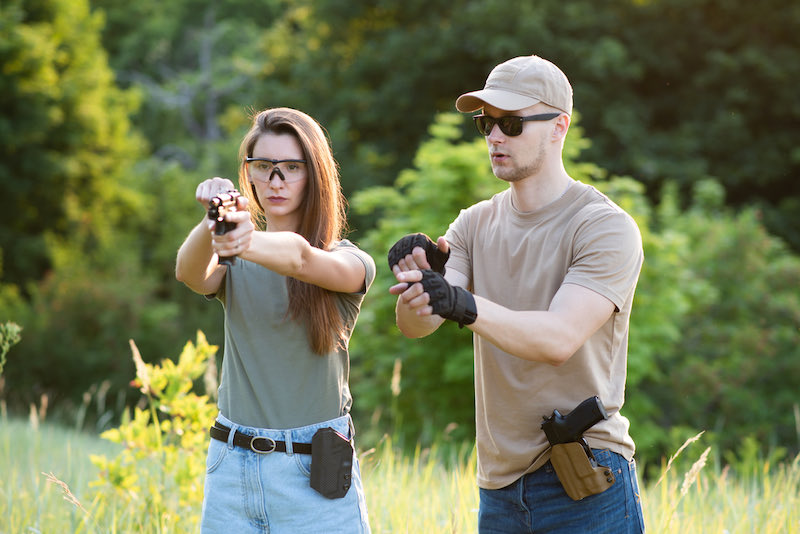 A male weapons instructor teaches a woman | micro compact pistol