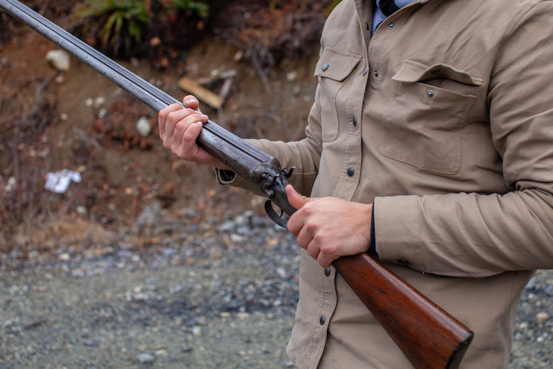 A man holds an old, antique, double-barrel shotgun | how to make a sawed off shotgun