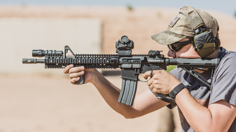 Man shooting black rifle on desert range wide shot | best military assault rifles