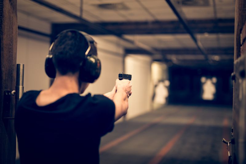 man-aiming-pistol-target-indoor-firing canike mete ss