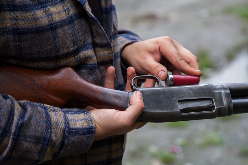 Closeup of Man Loading a Red Shotgun Shell into the Magazine of His Gun | Smith and Wesson Shotgun