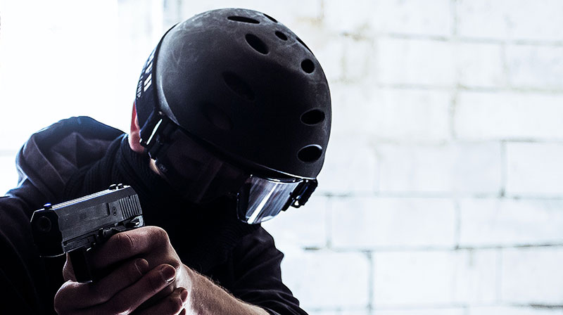 man in black helmet holding black gun | How Should You Hold a Handgun for Maximum Accuracy