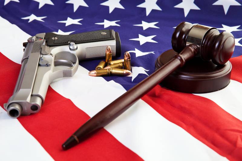 Photo of gavel, gun, and bullets over an american flag | red flag laws