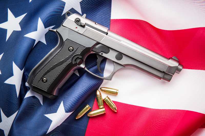 Pistol bullets, handgun on USA flag | red flag law
