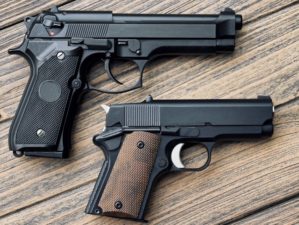 Two different hand guns on wooden background | Top 10 Coolest Handguns For 2022 | Featured