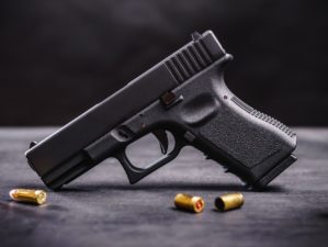 Black 9mm Pistol on a Black Wooden Table | Single Stack 9mm | Featured