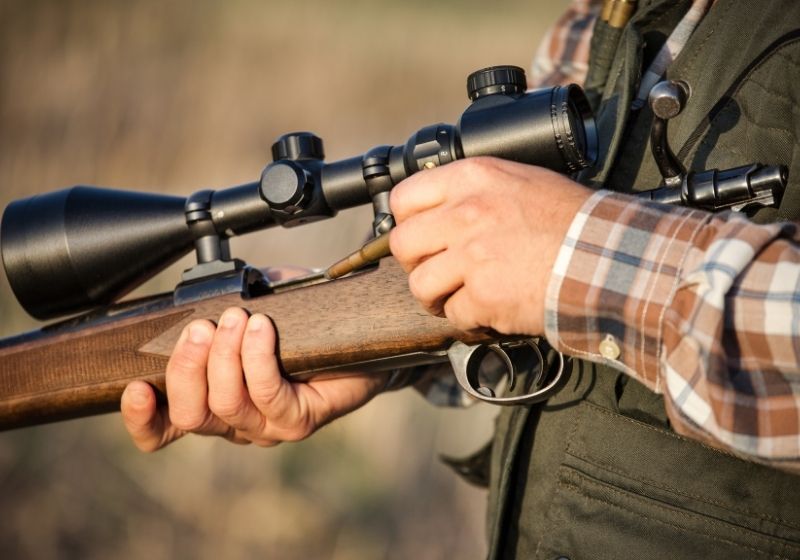 Hunter holding a rifle | What Should You Check Before Choosing a Firearm for Hunting