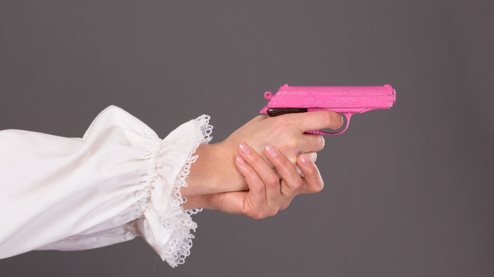 Child's Pink Plastic Gun in Woman's Hands | Pink Handgun | Featured