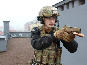 9mm pistols for military use a man in camouflage holding a machine gun