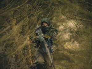 hunting rifles person in black and green camouflage jacket holding black rifle