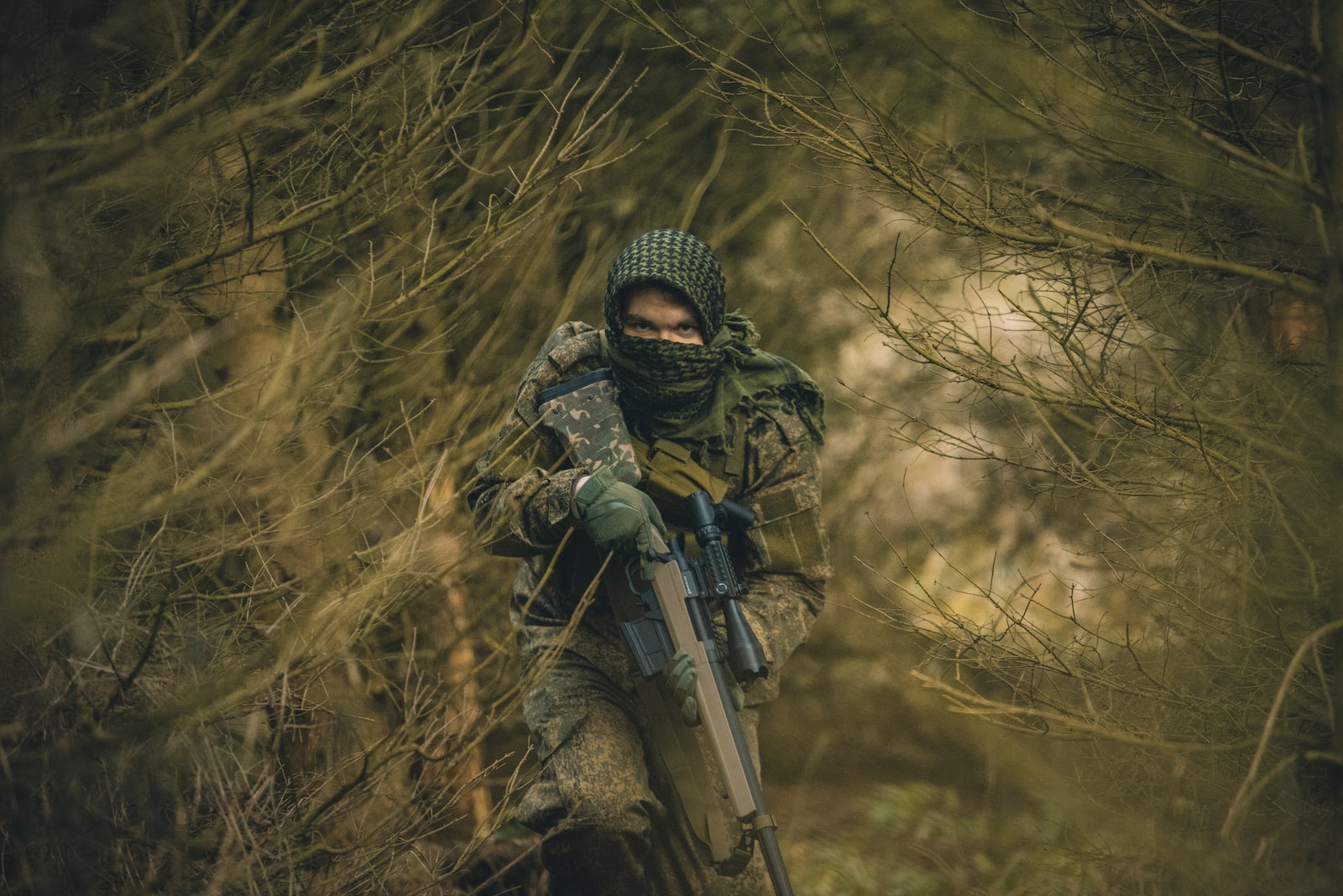 hunting rifles person in black and green camouflage jacket holding black rifle