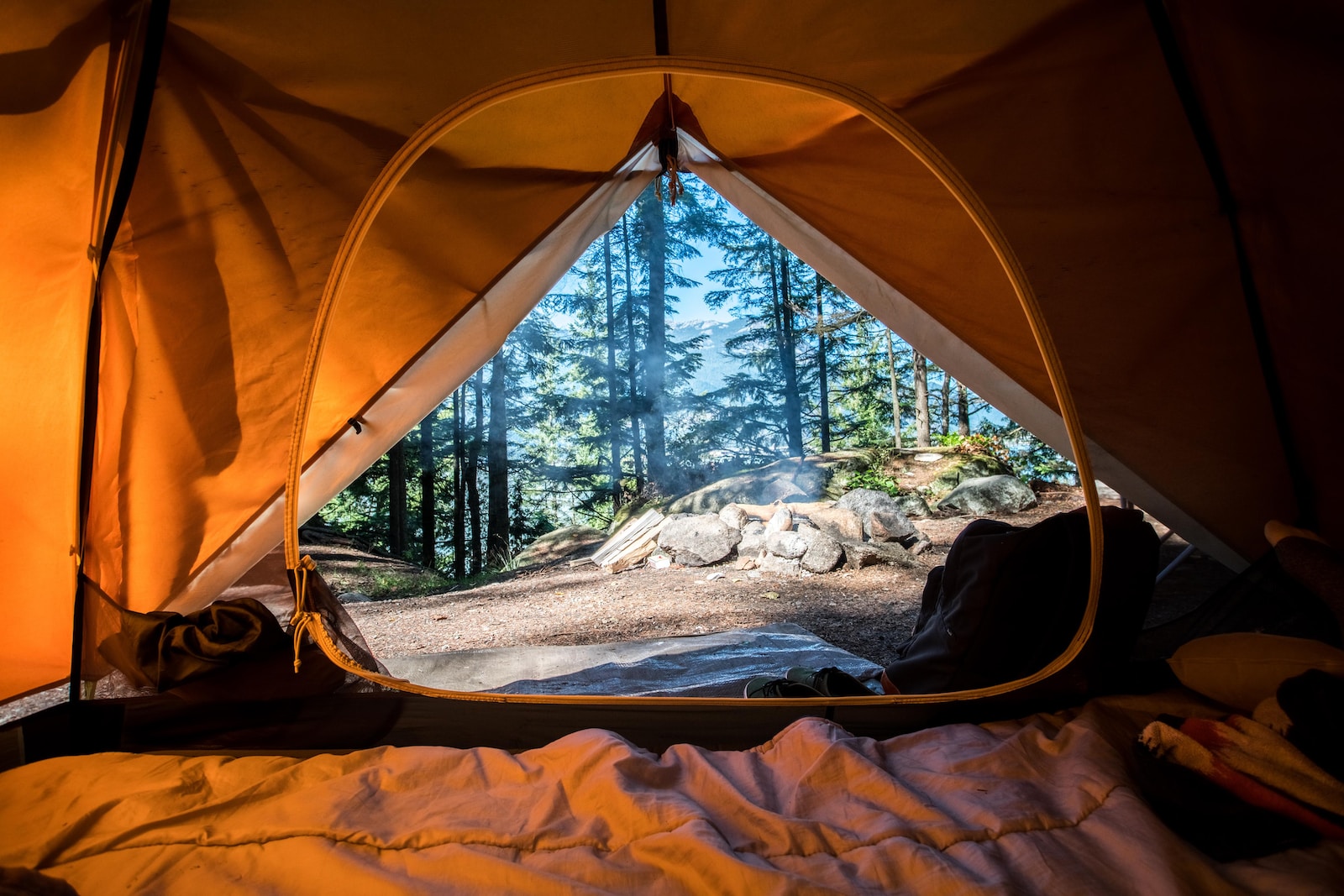 Camping orange camping tent near green trees