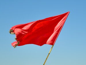 red flag on pole under blue sky during daytime